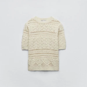 Beige stickad tröja med mönster - Säljer en beige stickad tröja med korta ärmar och ett snyggt, diskret mönster. Perfekt för lager-på-lager och passar till både jeans och kjol. Rund halsringning och mjukt material.