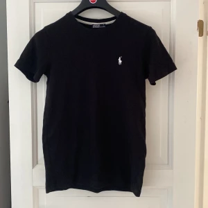 Svart t-shirt från Ralph Lauren - Tjena, säljer min polo ralph lauren T-shirt som inte är använd mycket då den försvann för länge sen och nu hittade jag den.  Den är i storlek S därmed passar den inte längre. 