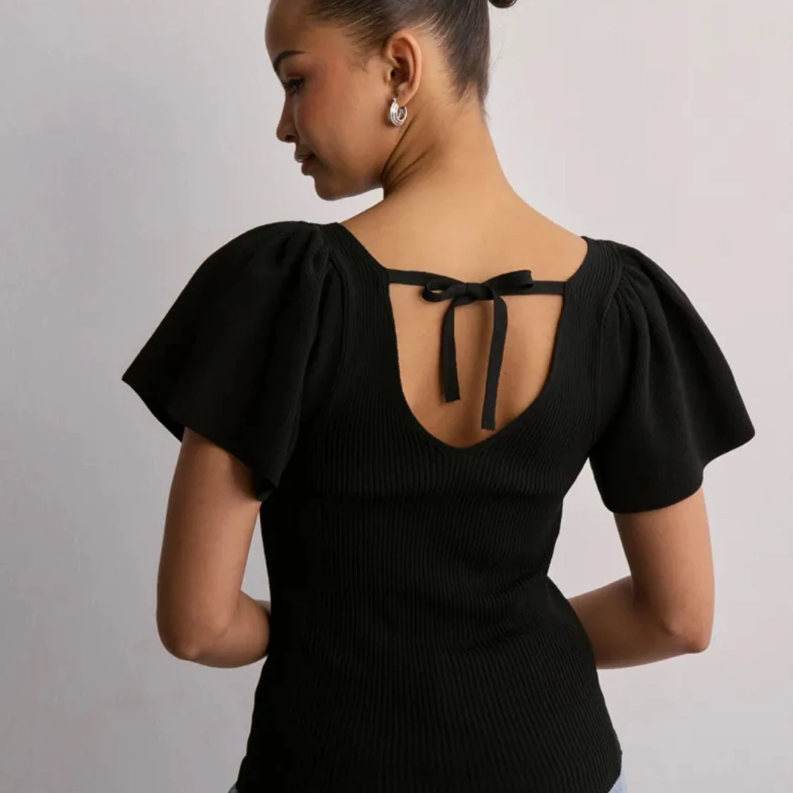 Svart ribbad topp med puffärmar och rosett - 1