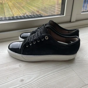 Lanvin Paris skor  - Svarta lanvin Paris skor i UK8 (motsvarar 42/43) köpta på care of Carl för 5000:- (bevis/äktighetsbevis finns) bra skick. Lite små defekter på sulan annars är den helt vit. Samt lite defekter på mockan, annars är den helt svart. Finns små hål vid hälarna under båda skorna också. (Det varken syns eller känns/påverkas något) priset är inte hugget i sten. Frågor eller funderingar? Bara att höra av sig. OBS! (Byte mot svarta/blåa loubs utan spikar och valentino flycrews/opens kan vara intressant!)