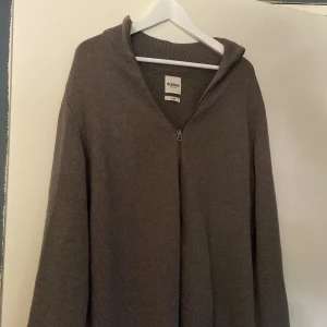 Grå stickad half zip-tröja Dobber - Mysig grå stickad tröja från Dobber i storlek large. Tröjan har en snygg half zip-dragkedja och ribbade detaljer vid krage och ärmslut. Perfekt för lager-på-lager och chill dagar. Enkel att matcha med jeans eller mjukis. Nypris 600