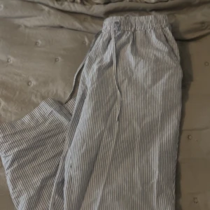 Randiga mjukisbyxor från Lager 157 - Säljer ett par blåvit randiga mjukisbyxor. Byxorna har en avslappnad passform och är perfekta för chill dagar hemma. Tillverkade i mjukt bomullsmaterial för extra komfort. Säljer på grund av ej kommit till andvändning.