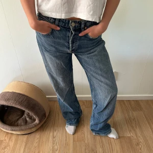 Blå raka jeansbyxor - Klassiska blå jeansbyxor med normal passform och raka ben. Perfekta för en avslappnad stil.