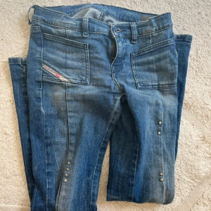 Blå lågmidjade bootcut jeans från Diesel - Säljer ett par blå lågmidjade jeans från Diesel, modell D-EBBEY YJ SP2. Jeansen har lite detaljer som knappar och mönster. Storleken är 152 men är själv 158 och passar fast de är lite tajta. Supersnygggaaa!! Tryck på köp! Pris kan diskuteras vid snabb affär.
