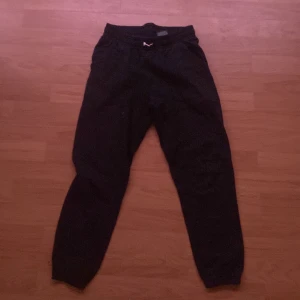 Svarta mjukisbyxor från H&M - Svarta mjukisbyxor från H&M med resår i midjan och vid bensluten. Perfekta för en avslappnad stil eller till träning. Klassisk modell utan synliga detaljer förutom diskret logga på insidan.