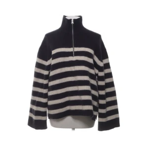 Randig stickad tröja med halv dragkedja från & Other Stories - Säljer en svart/blå och vit randig stickad tröja från & Other Stories med halv dragkedja och hög krage. Tröjan har långa ärmar och en avslappnad passform, perfekt för kyliga dagar.