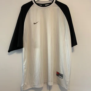 Vit och svart t-shirt från Nike - Säljer en klassisk vit t-shirt från Nike med svarta ärmar och liten Nike-logga på bröstet. Köpt på stadsmissionen men är i väldigt bra skick !