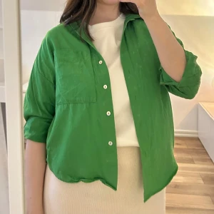 Grön skjorta från Mango - Snygg grön skjorta från Mango med klassisk krage och bröstficka. Skjortan har långa ärmar och knäppning framtill med vita knappar. Perfekt att bära öppen över en t-shirt eller stängd för en mer klassisk look.