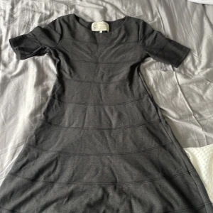 Grå klänning från Newhouse - Säljer en stilren grå klänning från Newhouse med korta ärmar och rund halsringning. Klänningen är i stl S men skulle kunna fungera för någon med en mindre storlek. 