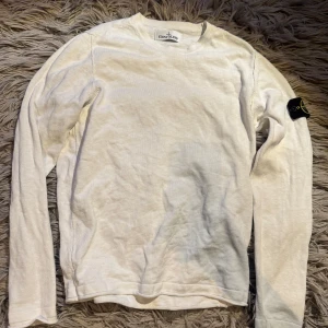 Stone Island tröja - Säljer en vit långärmad tröja från Stone Island med klassisk logotyp-patch på vänster ärm. Tröjan stickad vilket gör att den ser lite lyxigare ut. Tröjan har en ihopsytt hål på ryggen som inte syns när man har den på sig. Vilket dock leder till att priset sänks lite. 7/10 i skick bara pågrund av hånet annars har den inga defekter. Bara att skriva vid minsta fundering!