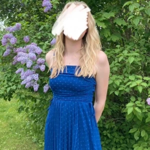 Blå långklänning med prickigt mönster - Säljer en blå långklänning med smala axelband och diskret prickigt mönster. Klänningen har rynkade detaljer upptill och ett lätt, luftigt tyg som faller fint. Perfekt för bal/skolavslutning eller en fin sommardag💓