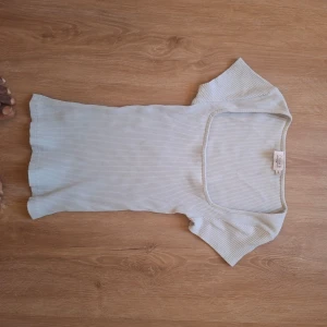 Ljusblå ribbad topp med fyrkantig ringning - Säljer en ljusblå ribbad topp från Bik Bok med korta ärmar och snygg fyrkantig ringning. Toppen är tight i passformen och passar perfekt till sommaren. Enkel och stilren design som är lätt att matcha.