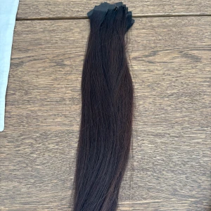 Mörkbrunt tejp extensions - Långt, rakt löshår i en djup mörkbrun nyans med tejpfästen upptill. Perfekt för att ge extra längd och volym till håret. Passar dig som vill ha ett naturligt och fylligt resultat. Fästena är 3 cm.  46 slingor hår motsvarar ungefär 4 paket extensions. Håret är äkta hår och är ej färgbehandlat vilket gör kvaliten bättre, vid frågor om färg osv skriv (är utbildad frisör) så hjälper gärna då jag har fler färger hemma!