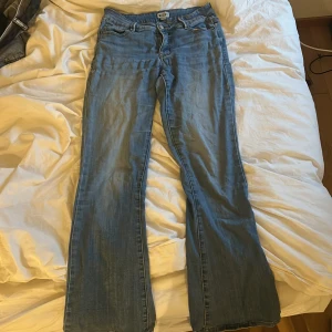 Blå bootcut jeans från Madlady - Säljer ett par klassiska blå bootcut jeans från Madlady I modellen tall. Jeansen har låg  midja och utsvängda ben. Perfekta till sneakers eller boots och passar dig som gillar en tidlös jeanslook.