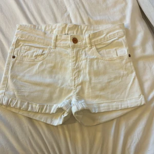 Vita jeansshorts från H&M - Tyvärr för små men inte mycket använda eller sönder. Snygga vita jeansshorts från H&M med klassisk femficksdesign och uppvikta benslut. Perfekta för varma dagar och enkla att matcha med olika toppar. Stängs med knapp och dragkedja framtill.