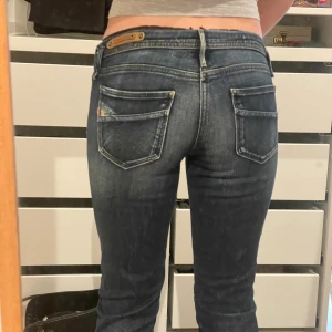 Lågmidjade mörknlå jeans - Jättesnygga lågmidjade jeans med liten bootcut längst ner på benet. Mer bilder kan tas