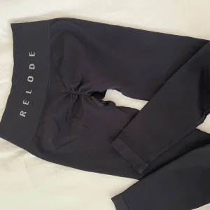 Svarta tights från Relode - Svarta tights från Relode med hög midja och scrunch-detalj bak. Dom är noppriga och har ett litet hål längst ner i scrunchen som går att sy ihop, därav priset