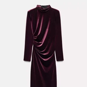 Vinröd sammetsklänning med öppen rygg - Säljer en vinröd långklänning i sammet med hög hals och långa ärmar. Klänningen har en snygg drapering framtill, öppen rygg och slits på sidan. Perfekt för dig som vill sticka ut på festen!