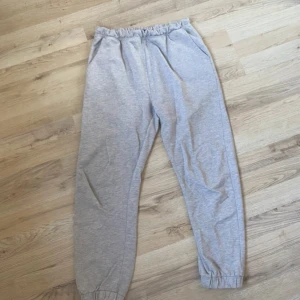 Grå mjukisbyxor från 157 - Säljer ett par klassiska grå mjukisbyxor från 157 med resår i midjan och vid bensluten. Byxorna har sidfickor och är perfekta för en avslappnad stil. Mjukt bomullsmaterial som är skönt att ha på sig.