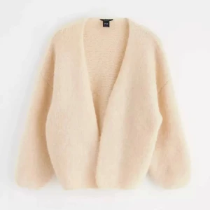 Beige fluffig kofta - Mysig och fluffig beige kofta med lång ärm och öppen front. Perfekt för lager-på-lager och ger en avslappnad look. Passar bra till både jeans och klänning.