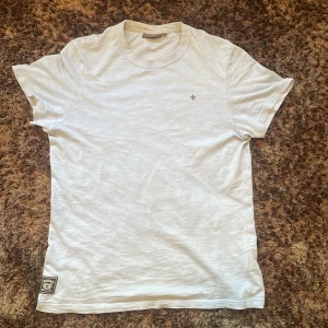 Ljusblå t-shirt från Morris Stockholm - Ljusblå t-shirt från Morris Stockholm i bomull med klassisk passform. T-shirten har rund hals, liten broderad logga på bröstet och en snygg patch nertill. Perfekt basic med stilrena detaljer och skön känsla. Storlek S men sitter som M. Har bara använt den nån gång så nästan helt ny.