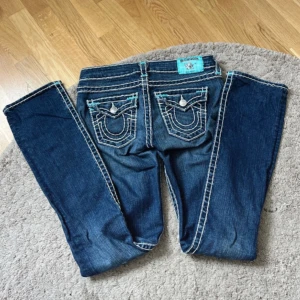 True Religion Jeans - Snygga blå jeans från True Religion, modell Billy Super T. Vita sömmar och ljusblå detaljer, W 26