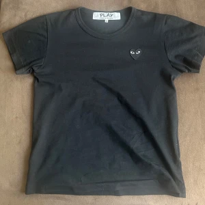 Comme des Garçons Play T-shirt - Svart, - Comme des Garçons Play T-shirt - Svart, Storlek S (Nyskick)  Säljer en stilren och klassisk svart Comme des Garçons Play T-shirt med det ikoniska hjärt- logotypen med ögon på bröstet. Storlek S.  Nästin intil nyskick  Inga fläckar, hål eller tvättslitage  100% äkta - se etikett på bilden  Passar både män och kvinnor (unisex- modell)  Perfekt för dig som vill ha en tidlös designer-T- shirt i toppskick.  Köpt för: 950  Säljer för: 449  Skickas snabbt & spårbart. PRIS KAN FÖRHANDLAS