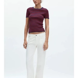 Vita raka jeans från Zara - Snygga vita jeans från Zara med rak passform och klassisk femficksdesign. Byxorna har normal midja och stängs med dragkedja och knapp. Perfekta för en clean och fräsch look, tillverkade i bomull för en skön känsla.