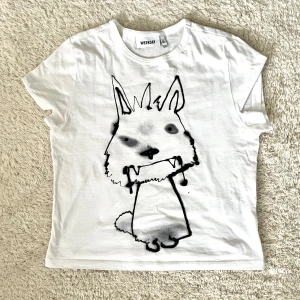 Vit t-shirt med print från Weekday - Vit t-shirt från Weekday med ett stort svart  tryck!! Knappt använd 
