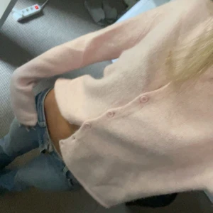 Ljusrosa kofta från Gina Tricot - Superfin ljusrosa kofta från Gina Tricot med lång ärm och knappar framtill. Mjuk och lite fluffig känsla, perfekt att slänga på sig över ett linne eller t-shirt. Enkel och stilren modell som är lätt att matcha med jeans eller kjol.