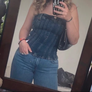 Denim tubtopp  - Säljer en tubtopp i blå denim med knappdetalj.