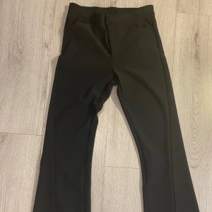 Utsvängda kostymbyxor från Lindex - Utsvängda Kostymbyxor från lindex storlek S. En öppen slits längs ner.