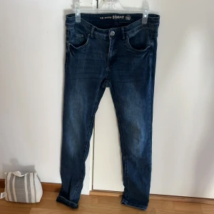 Mörkblå skinny jeans Emma Denim - Mörkblå skinny jeans från Emma Denim i klassisk femficksmodell. Jeansen har snygga slitningar och en smal passform som sitter lätt tajt längs benen. Tillverkade i stretchig bomullsdenim för extra komfort. Perfekta för dig som gillar en stilren och modern look.🌸