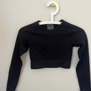 Svart croppad långärmad topp Aim'n - Säljer en svart croppad långärmad topp från Aim'n. Toppen är ribbad och har en tight passform och materialet är stretchigt och bekvämt. Hittar inte längre på sidan så osäker på nypris men säljer för 100kr💗