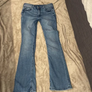 Blå bootcut jeans från H&M  - Snygga blå jeans från H&M med klassisk bootcut-passform och femficksdesign och är tillverkade i mjukt denimtyg. Perfekta för dig som gillar en retroinspirerad look med utsvängda ben.