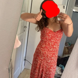 Röd blommig långklänning Gina Tricot - Superfin röd långklänning från Gina Tricot med vita små blommor. Klänningen har smala axelband och en figurnära passform upptill. Perfekt för varma dagar och somriga vibes! Använd 2 gånger, ny pris 499, pris kan diskuteras 💕