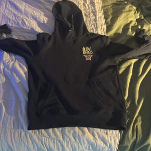 Svart hoodie från Morris med brodyr - Svart hoodie från Morris med snyggt broderat emblem och brittisk flagga på bröstet. Tröjan aldrig använd nypris 1500