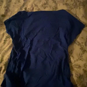 Blå topp från SHEIN, storlek M - En enkel blå topp från SHEIN i storlek M. T-shirttyp med korta ärmar och öppen på ryggen. Snygg att matcha med jeans eller kjol för en clean look. Materialet känns lätt och passar perfekt för varmare dagar.