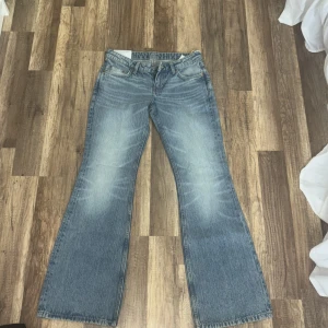 Bootcut jeans från Weekday Nova 26/32 - Snygga ljusblå bootcut jeans från Weekday, modell Nova. Jeansen har låg midja, slim fit upptill och utsvängda ben. Tillverkade i ekologisk och återvunnen bomullsblandning. Klassisk femficksmodell med slitningar för en cool vintagekänsla. Oanfvända jeans!!