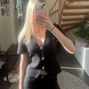Svart kortärmad kofta med knappar - Snygg svart topp från Gina Tricot. Knappt använd