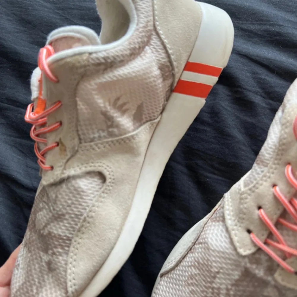 Snygga beige sneakers från GANT med orange detaljer och snörning. Skorna har en rund tå och en bekväm sula. Perfekta för en avslappnad stil.. Kengät.