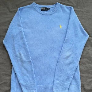  Ralph Lauren Sweatshirt  - Säljer en stilren ljusblå tröja från Polo Ralph Lauren med det klassiska broderade logotypen i gult på bröstet. Tröjan har långa ärmar och ribbade muddar vid ärmslut och nederkant. Perfekt för en avslappnad och snygg look. För mer information och detaljer kontakta mig! 