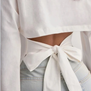 Vit långärmad topp med knyt - Snygg vit långärmad topp med knyt i ryggen. Helt ny prislappen är kvar och endast testad🩷