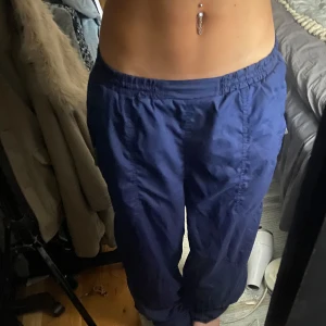 Blå puffiga y2k byxor! - Säljer ett par blå byxor med elastisk midja och praktiska fickor. Perfekta för en avslappnad stil och bekväma att bära hemma eller på språng. Stora och stretchiga, passar både xs till m