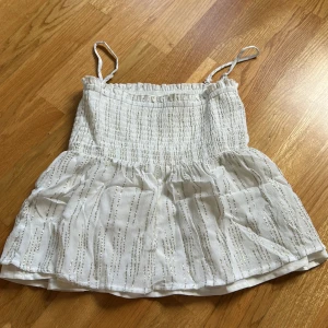 Gina multi topp - Säljer en söt vit linnetopp eller om man vill använda som kjol eftersom axelbanden går att ta av💗Från Gina Tricot med glittriga detaljer. 