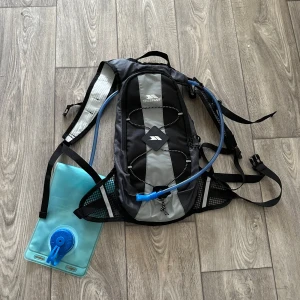 Svart och grå ryggsäck från Trespass - Praktisk ryggsäck från Trespass i svart och grått med inbyggd vätskesystem. Perfekt för vandring eller cykling med justerbara remmar och flera fack för förvaring. Endast använd 1 gång, så jättefint skick!!🩷🚴