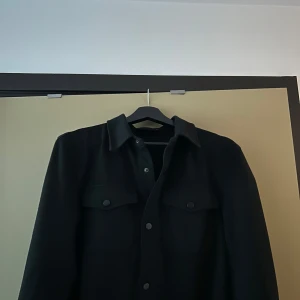 Zara Overshirt - Säljer en stilren Overshirt från Zara med knappar upptill. Tröjan är i mycket bra skick och perfekt för en avslappnad look. Storlek S men passar även XS