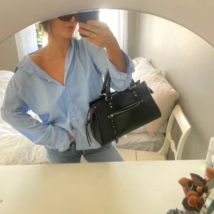 Ljusblå skjorta från 157 - Säljer en stilren ljusblå skjorta från 157. Skjortan har en klassisk krage och knappar framtill. Perfekt nu inför vår och sommar. Passar bra till både vardag och mer uppklädda tillfällen.