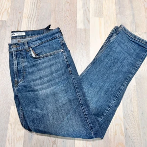 Blå Zara jeans - Snygga blå jeans från Zara med klassisk femficksdesign och dragkedja. De har en rak passform och är tillverkade i ett slitstarkt denimtyg. Perfekta för en avslappnad stil.
