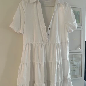 Vit klänning från Zara - Säljer en söt vit klänning från Zara med korta ärmar och knappar framtill. Klänningen har en luftig design med volanger!🩷🩷🫶🏼
